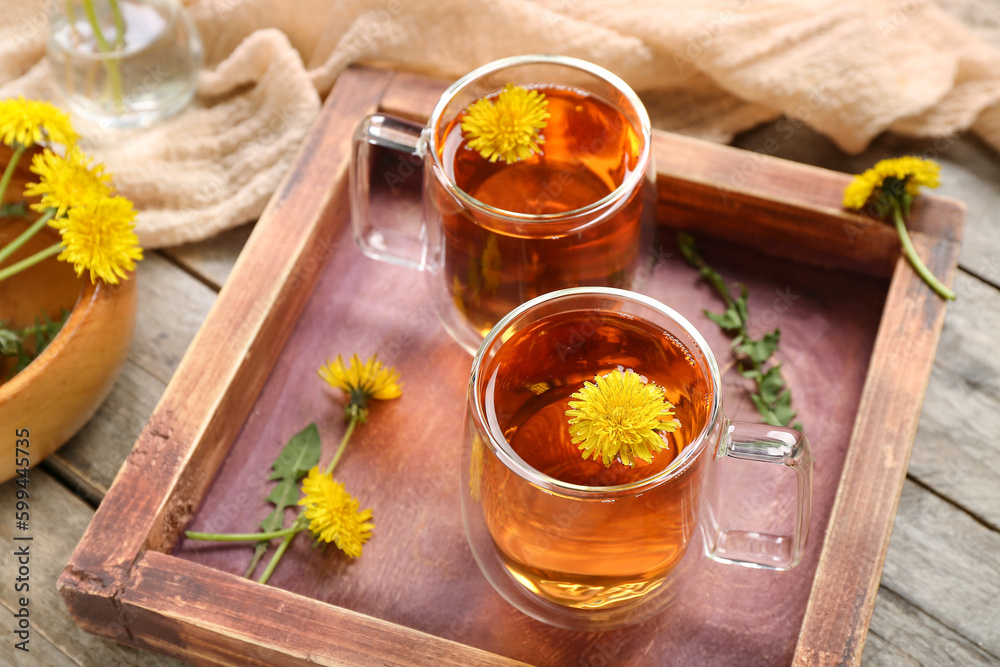 Board with glass cups of healthy dandelion tea on wooden background Board with glass cups of healthy dandelion tea on wooden background