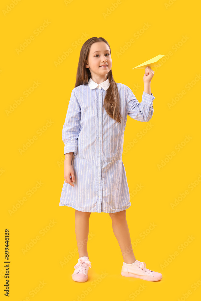 Little girl with paper plane on yellow background. Children's Day celebration Little girl with paper plane on yellow background. Children's Day celebration