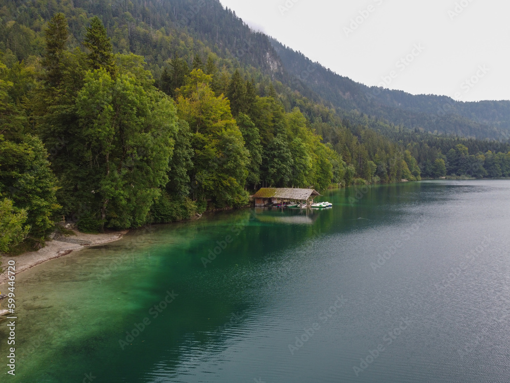 German wooden summer house overlooking scenic lake at mountains. Bavarian Alps.