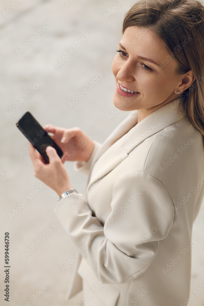 Cheerful woman with smartphone on street Cheerful woman with smartphone on street