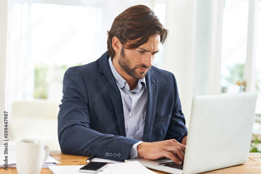 Focus and determination gets good results. A handsome businessman hard at work on his laptop. Focus and determination gets good results. A handsome businessman hard at work on his laptop.