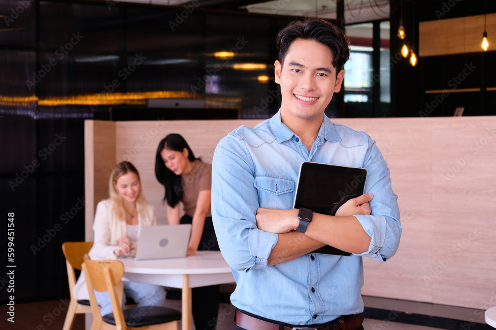 Fototapeta premium smiling young businessman stand holding tablet business idea.