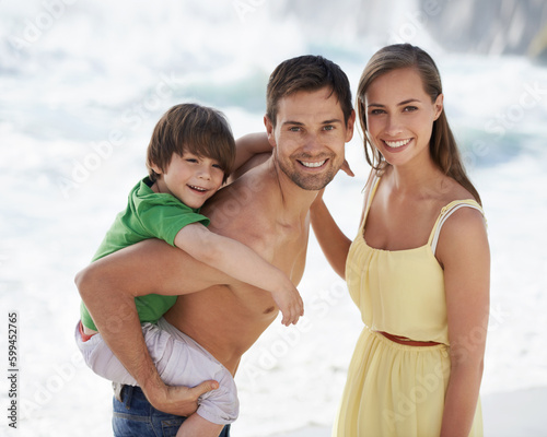 Family, child and happy portrait at beach on travel holiday in summer with a smile and piggy back fun. A man, woman and kid or son playing together on vacation at sea with love, care and happiness © Mapodile/peopleimages.com