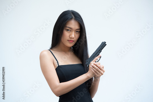 Sexy beauty young woman in black camisole posing with gun on white background. Girl in camisole with gun hand sexy brunette woman gun plain background.