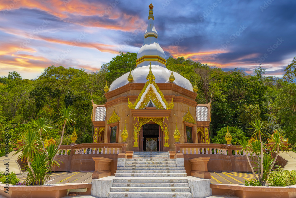 Beautiful Wat Buddhist temple in Phuket Town Thailand. Decorated in beautiful ornate colours of Gold Brown and White. Sunset Sunrise lovely sky and cloud colours