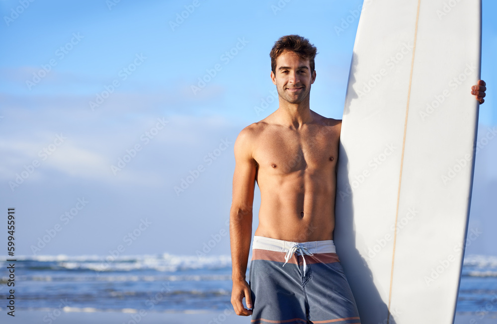 Obraz premium Chasing waves is his passion. A handsome young surfer at the beach craving a good wave.