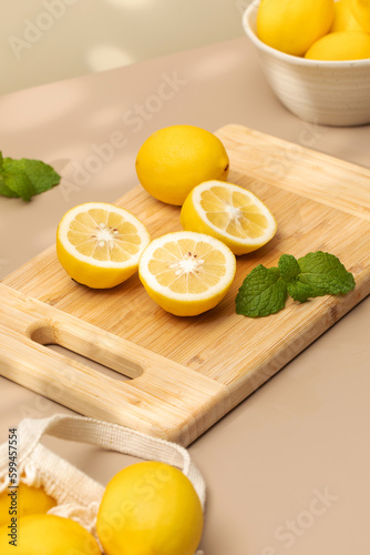 Whole and halves of yellow lemons on a wooden board. Juicy ripe lemons.