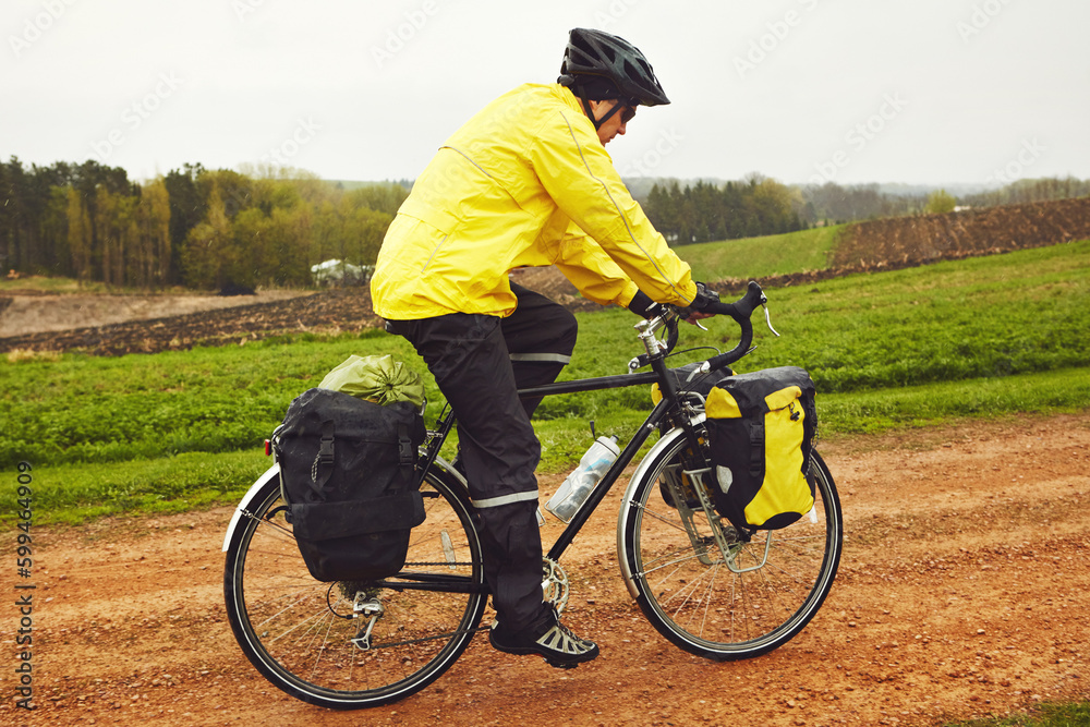 Fototapeta premium He spends his free time on the road. Full length shot of a male cyclist enjoying a bike ride on a wet winters morning.