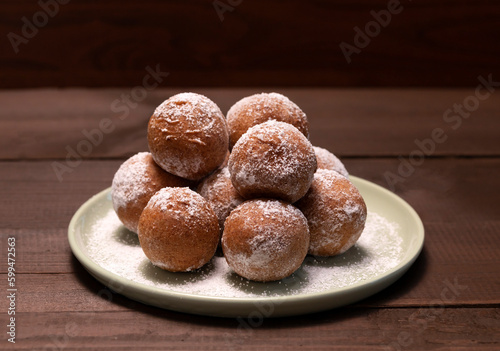 Delicious Donuts, Zeppole Or Paczki On Plate With Powdered Sugar On Wooden Table. Fat Thursday Carnival or Tlusty Czwartek Celebration, Christian tradition. Doughnut, Horizontal Plane.