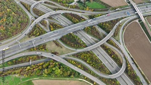Aerial drone view of a multi-level highway intersection with moving cars near the city of Stuttgart, Germany. Trucks move along a multi-level road junction. The concept of the urban. photo