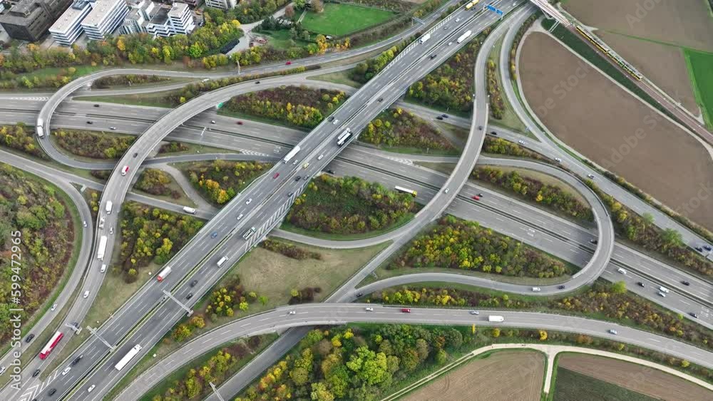 Aerial drone view of a multi-level highway intersection with moving cars near the city of Stuttgart, Germany. Trucks move along a multi-level road junction. The concept of the urban.
