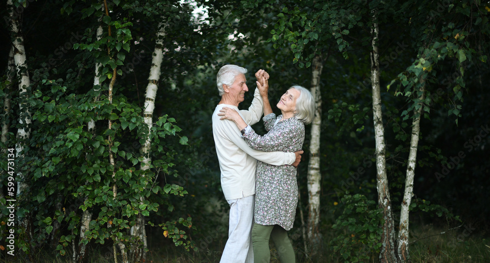 Elderly nice couple dancing iin the forest Elderly nice couple dancing iin the forest