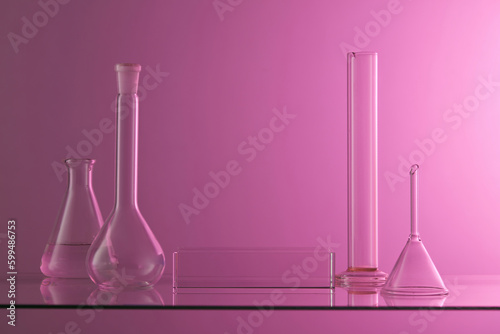 Laboratory concept with some flasks, glass funnel and tube. A transparent podium in rectangle shape with blank space for product promotion photo