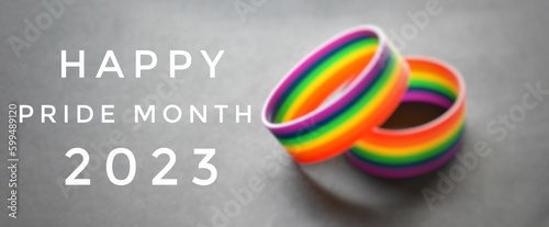 Happy pride month 2023 with blurred rainbow wristbands background, concept for LGBT community celebrations in pride month, June, around the world.