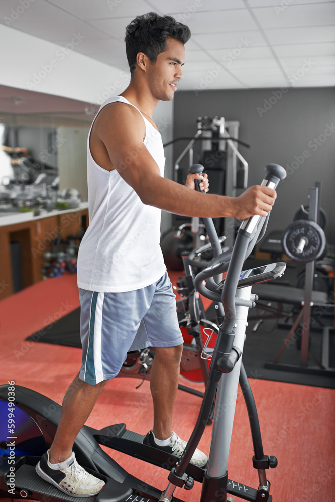 Fototapeta premium Hes always in the gym. A young ethnic man exercising in the gym.