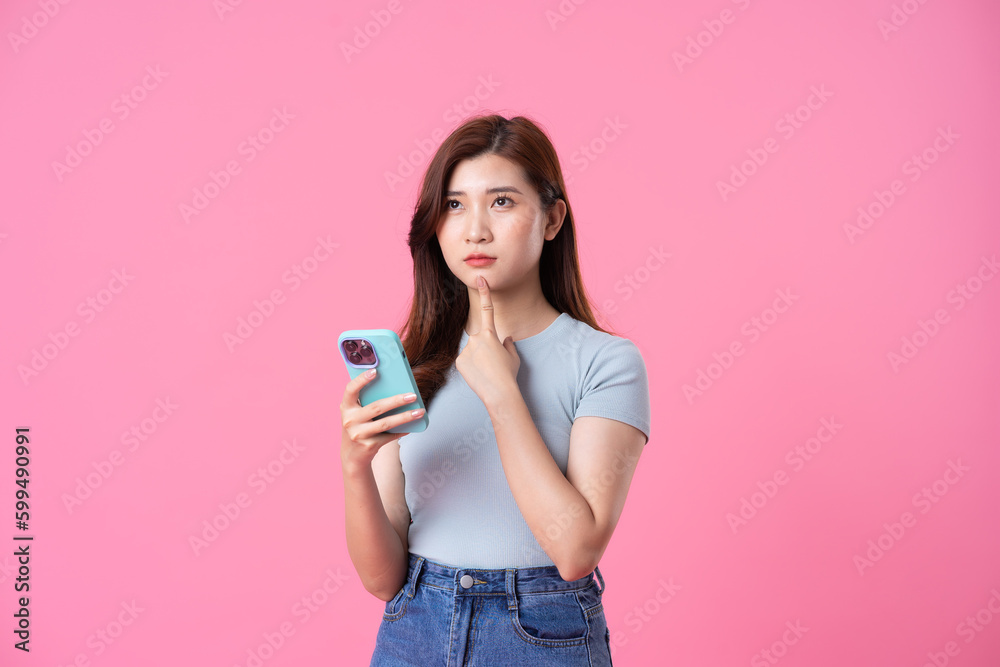 portrait of young asian girl posing on pink background