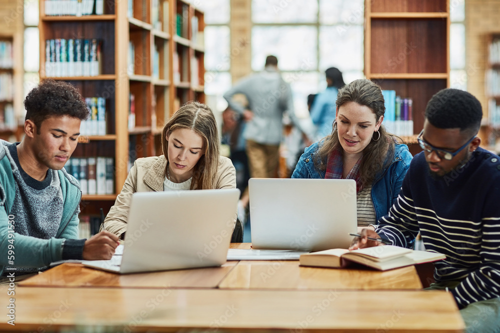 Staying fully engaged in their education. a group of university students working in the library at campus. Staying fully engaged in their education. a group of university students working in the library at campus.