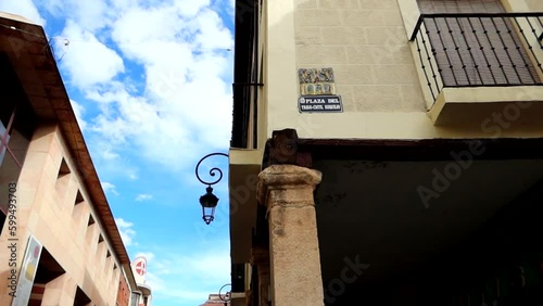 Low-angle shot of castilian stucco walls and balcony on sunny day. Panning left photo