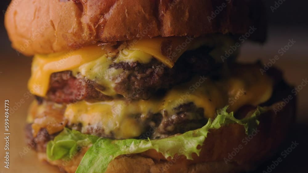 Macro of A justmade juicy burger with double beef patties, vegetables, lettuce, and cheese is