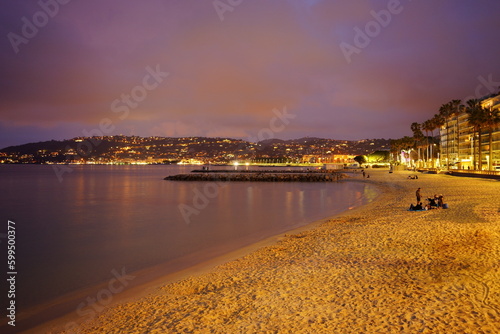 Un bel tramonto sulla Costa Azzurra a juan le Pins, con persone sulla spiaggia che si godono la serata in compagnia. photo