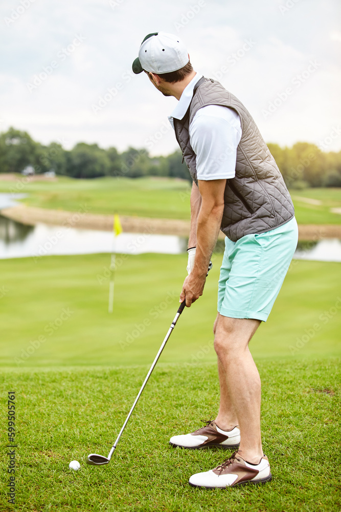 Fototapeta premium Lining up the shot. Full length shot of a handsome young man playing a round of golf on a golf course.