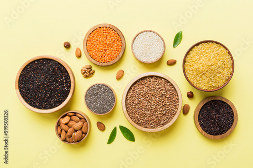 Various superfoods in smal bowl on colored background. Superfood as rice  chia  quinoa  lentils  nuts  sesame seeds  almonds. top view copy space