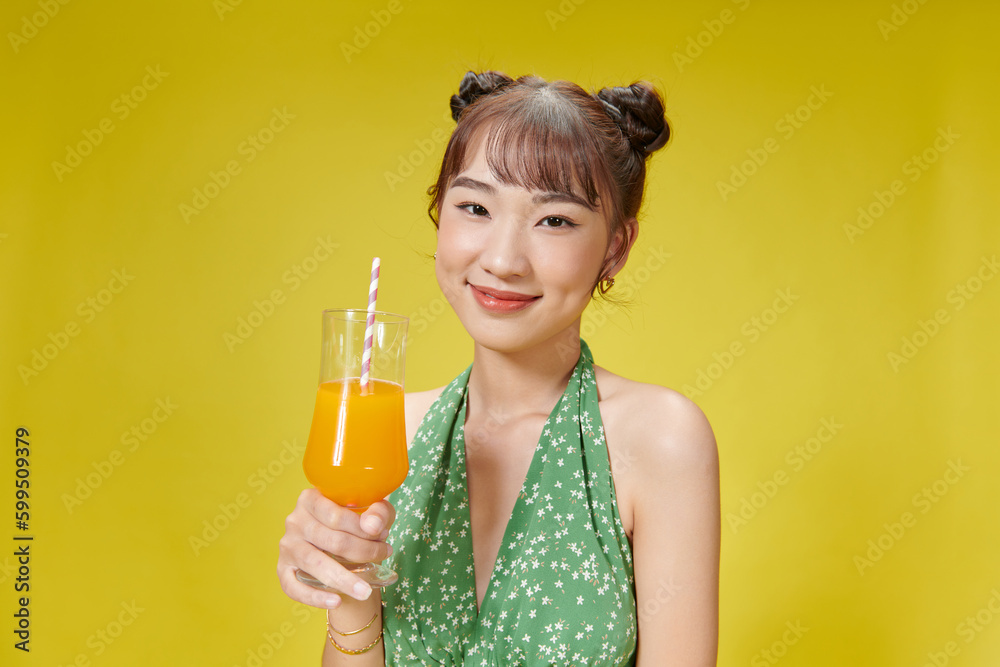 Beautiful young woman with orange juice on yellow background Beautiful young woman with orange juice on yellow background