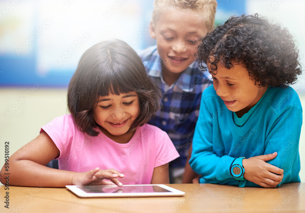 Learning the ABCs of technology. elementary school children using a digital tablet while sitting in class. Learning the ABCs of technology. elementary school children using a digital tablet while sitting in class.