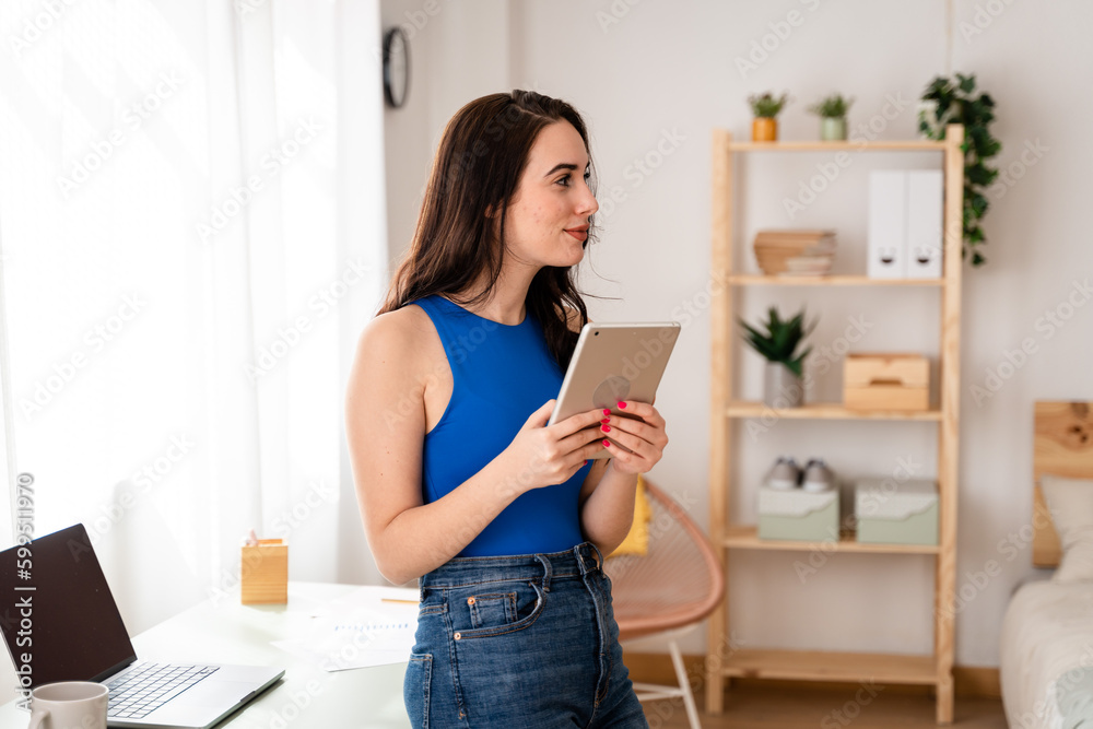 Woman working remotely looking at emails on digital tablet. Woman working remotely looking at emails on digital tablet.