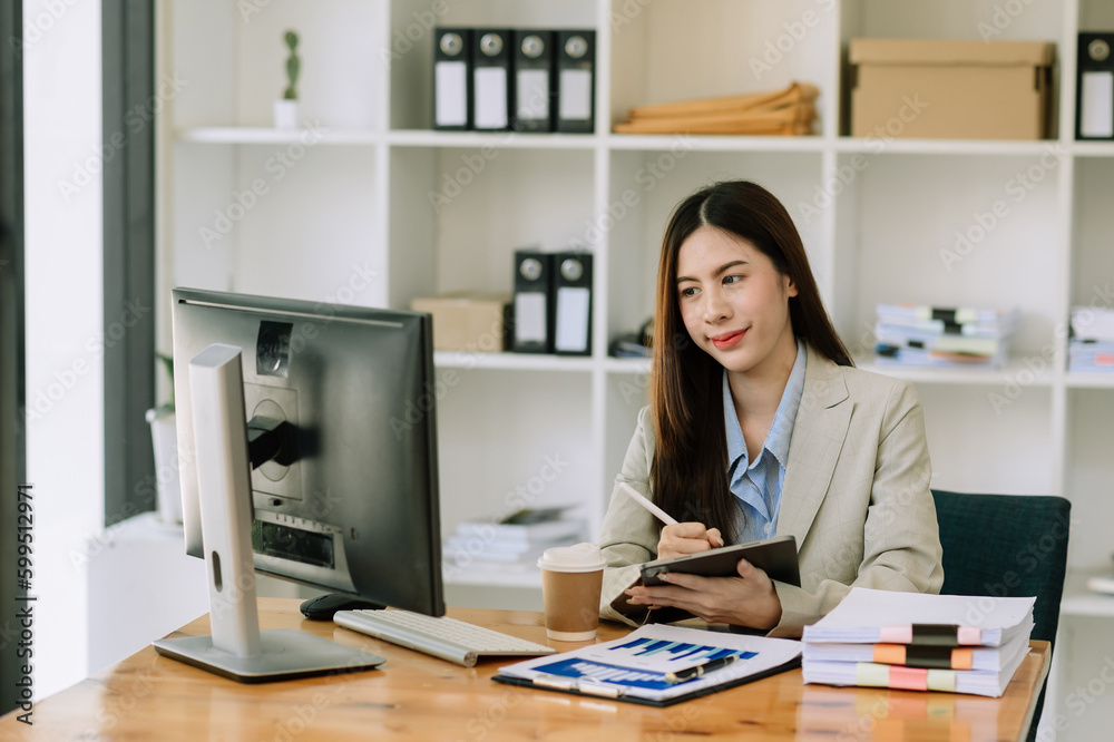ฺeautiful woman using laptop and tablet while sitting at her working place. Concentrated at work... ฺeautiful woman using laptop and tablet while sitting at her working place. Concentrated at work...