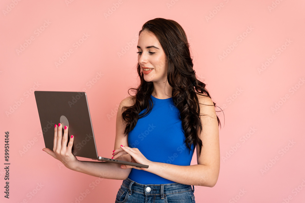 Young woman using laptop in studio shot. Young woman using laptop in studio shot.
