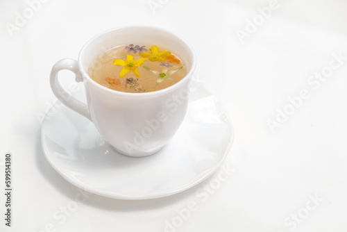 Healthy herbal tea in a white cup with medicinal herbs and flowers for relaxation and wellness