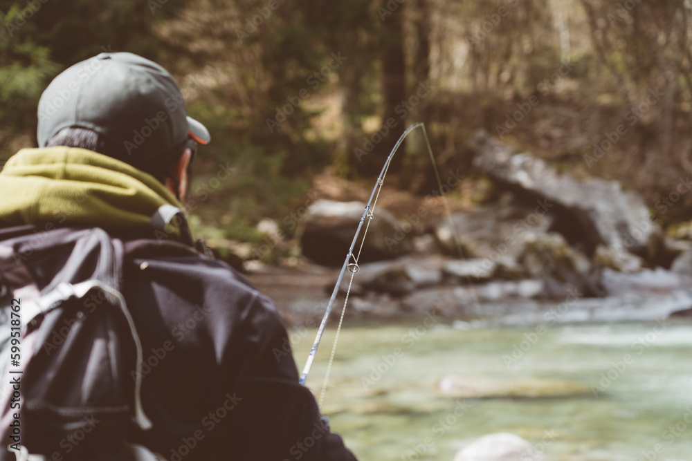 Pescatore in azione durante una battuta di pesca nelle acque di un torrente montano in Trentino Alto Adige, Italia Pescatore in azione durante una battuta di pesca nelle acque di un torrente montano in Trentino Alto Adige, Italia