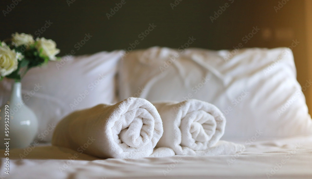 White towel roll on a white pillow and bed decoration in bedroom interior to vintage style hotel. vacation concept. White towel roll on a white pillow and bed decoration in bedroom interior to vintage style hotel. vacation concept.