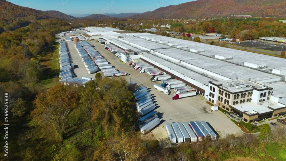 Top view of giant logistics center with many commercial trailer trucks unloading and uploading retail products for further shipment. Global economy concept Top view of giant logistics center with many commercial trailer trucks unloading and uploading retail products for further shipment. Global economy concept