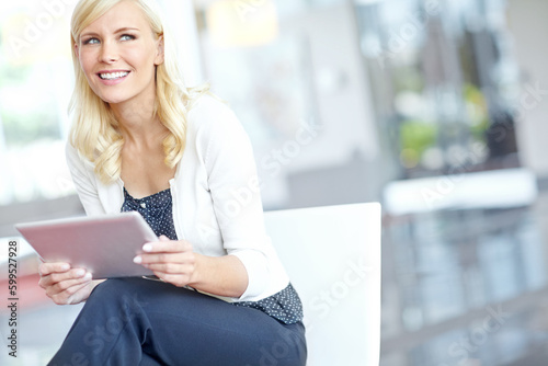 Using the tools of the office trade. a smiling business woman holding her digital tablet in an office environment with copyspace.