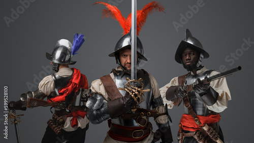 Shot of medieval conquistador staring at camera with two comrades on his sides.