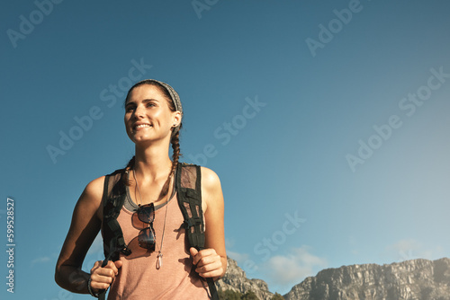 Live with a little adventure. a young woman out on a hike through the mountains. photo