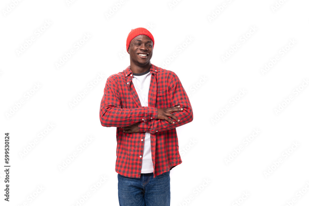 successful confident young american man in red cap and plaid shirt shows calm on white background with copy space successful confident young american man in red cap and plaid shirt shows calm on white background with copy space