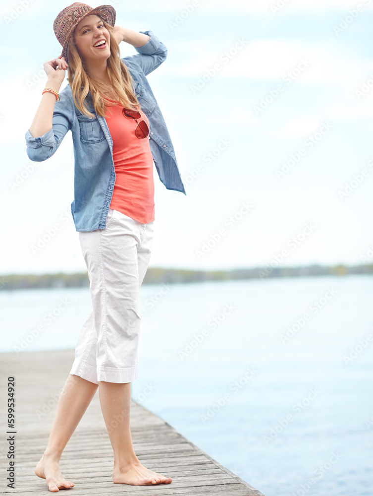 Greeting the day. A happy young woman standing on a pier next to a lake. Greeting the day. A happy young woman standing on a pier next to a lake.
