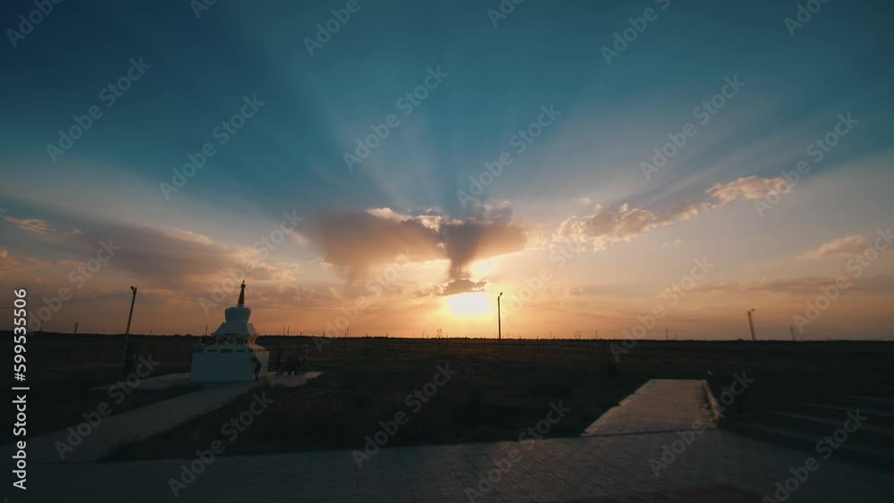 Enlightenment stupa in a Buddhist temple complex against the backdrop of a stunning sunset