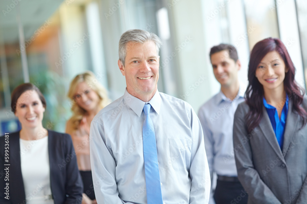 Business as usual. A group of businesspeople standing confidently in a office setting. Business as usual. A group of businesspeople standing confidently in a office setting.