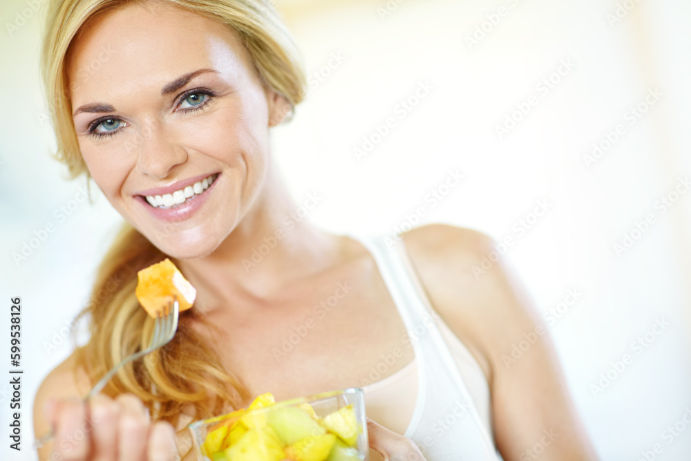 Healthy and delicious. Attractive young blonde woman enjoying a delicious fresh fruit salad at home. Healthy and delicious. Attractive young blonde woman enjoying a delicious fresh fruit salad at home.