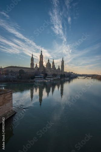 del Pilar basilica, one of the important architectural symbols of zaragoza, and the Ebro river and its reflection with sunset colors and clouds