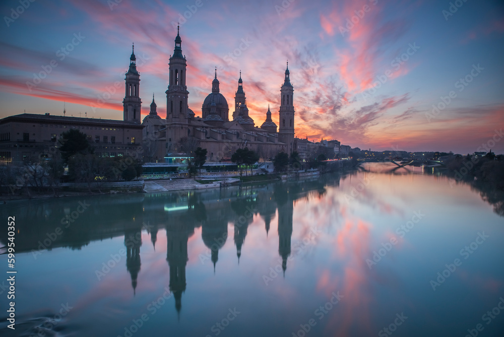 del Pilar basilica, one of the important architectural symbols of zaragoza, and the Ebro river and its reflection with sunset colors and clouds