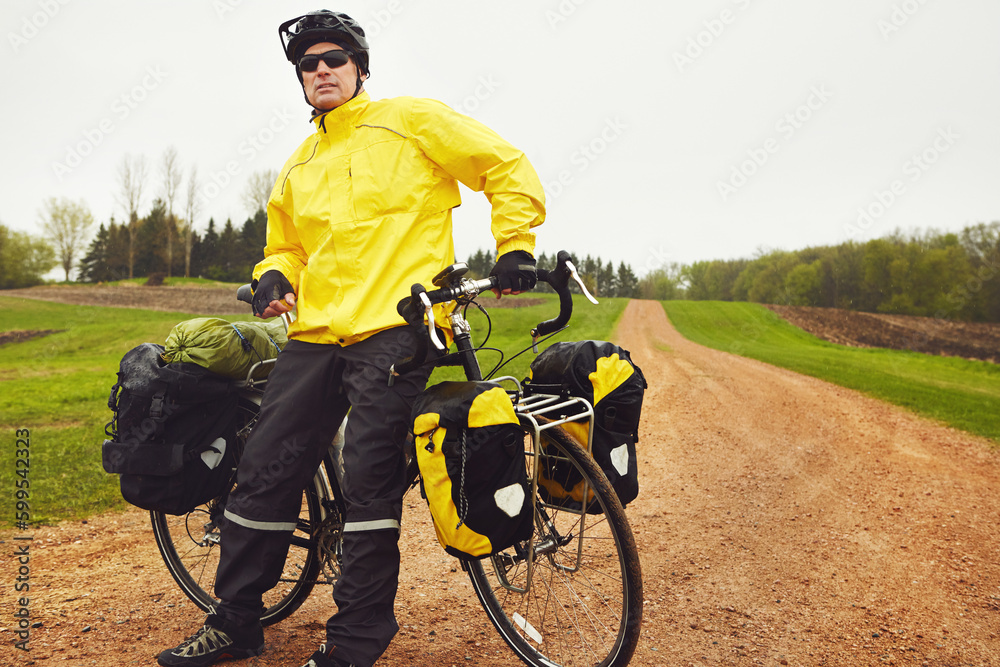 Obraz premium Cycling is an all-weather sport. a male cyclist enjoying a bike ride on a wet winters morning.