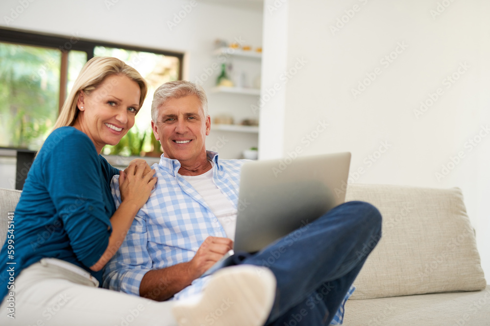 We enjoy exploring the online world together. Portrait of a mature couple using a laptop together at home.