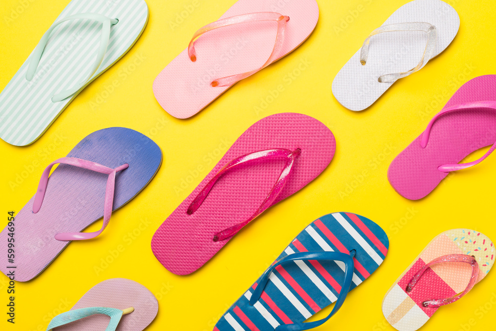 Many bright flip flops on color background, top view Many bright flip flops on color background, top view