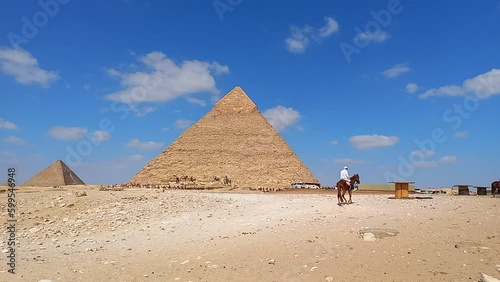 Time lapse con nuvole veloci che scorrono sulla Piramide di Cheope e un dromedario in movimento photo