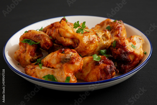 Homemade Grilled Chicken Wings with Parsley on a Plate, side view.